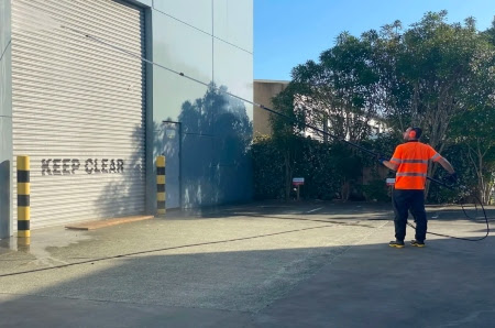 A The Exterior Group team in uniform and safety gear standing in front of a commercial building. 