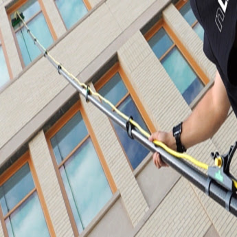 A The Exterior Group technician using a low-pressure cleaning tool to clean exterior.