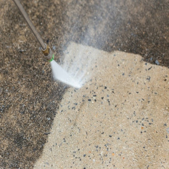 A professional grade pressure washer being controlled by a The Exterior Group technician.