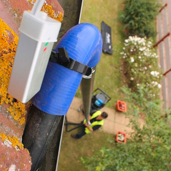 A The Exterior Group technician cleaning second-story gutters with a gutter vacuum.