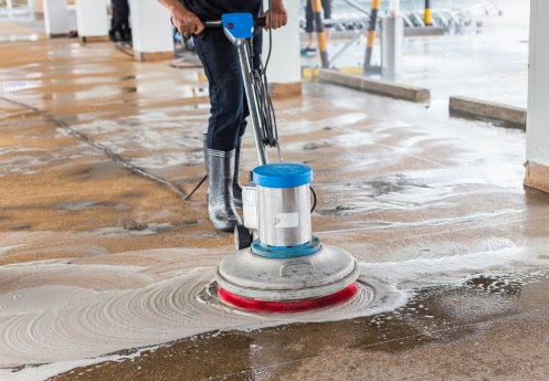  A The Exterior Group technician using a professional grade pressure washer next to a pool. 